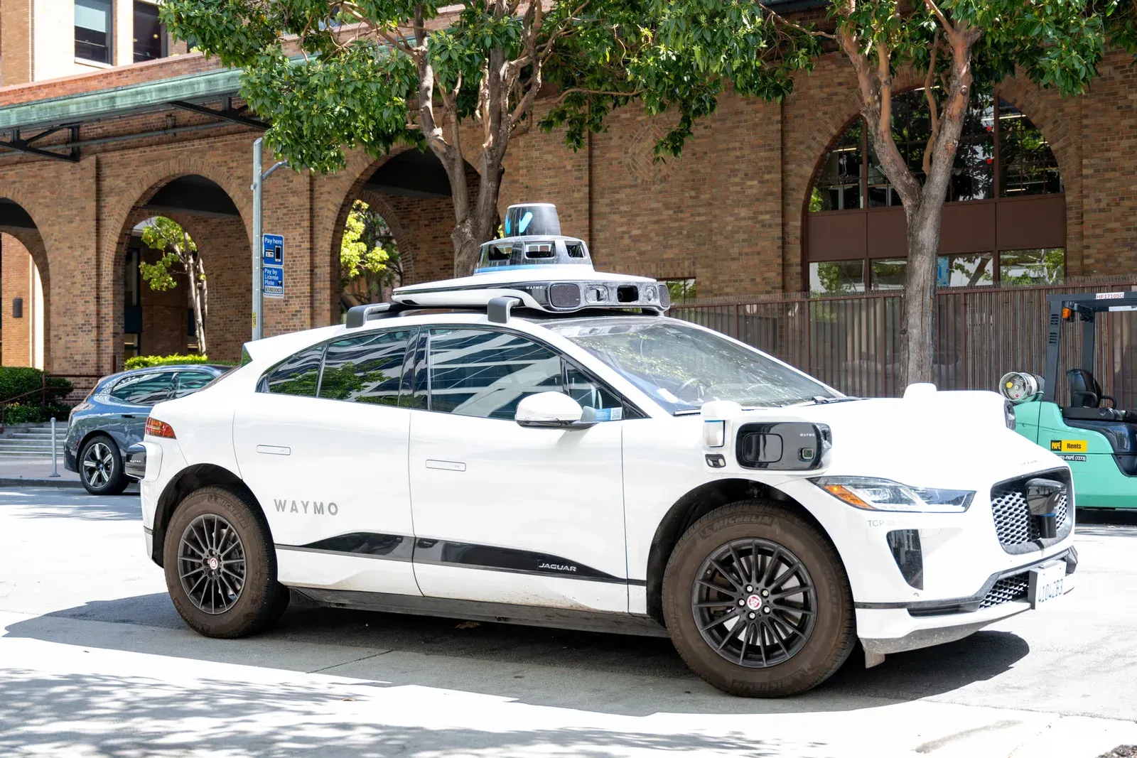 A Waymo robotaxi parked at a city curb