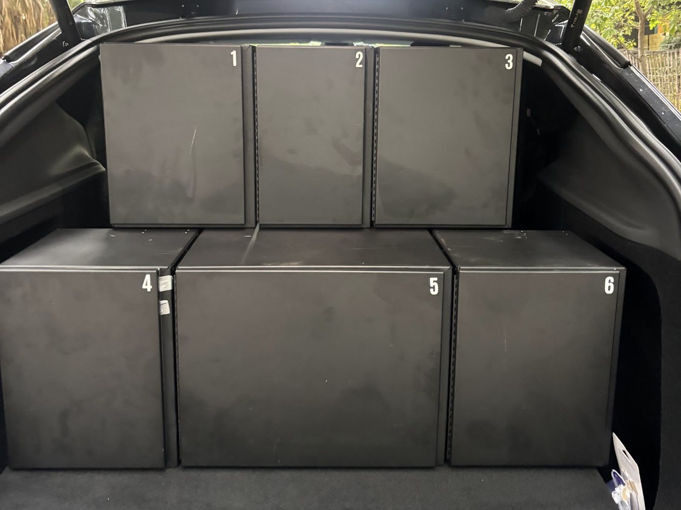 Autolane lockers closed in a Tesla cargo area, each compartment numbered